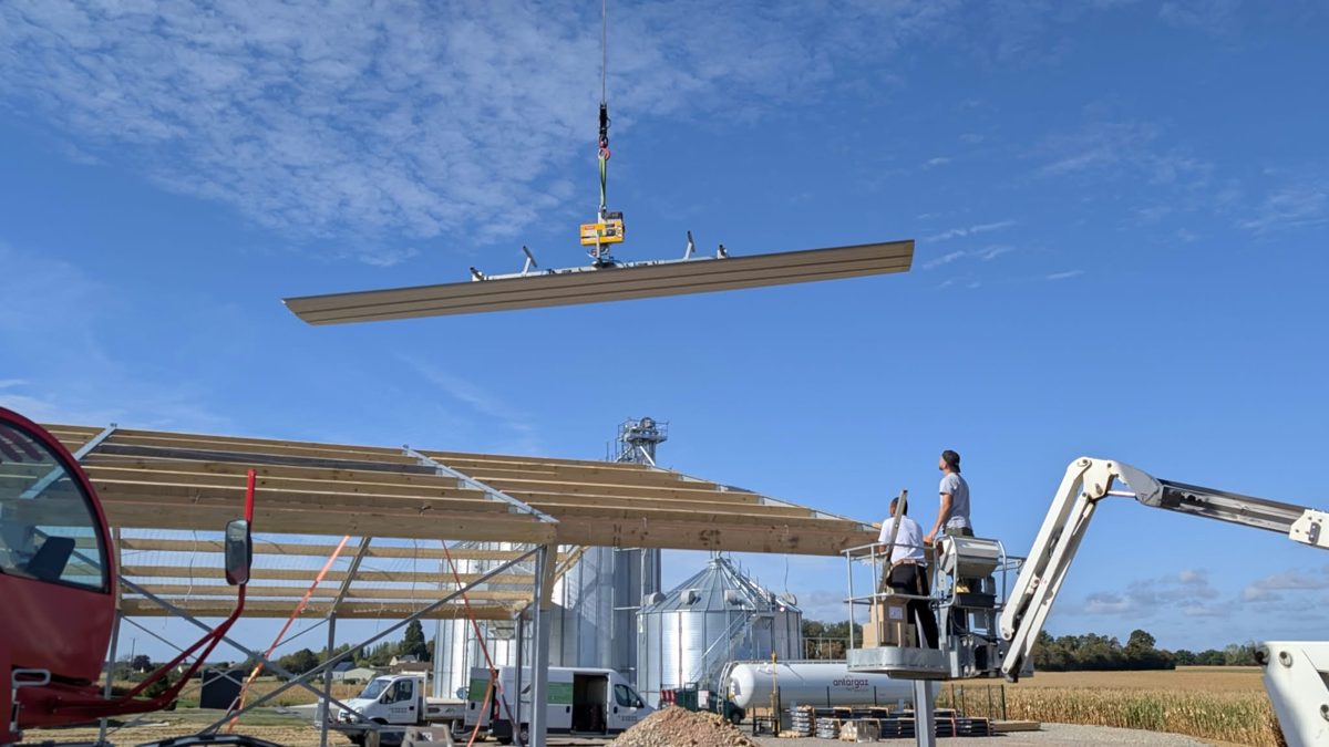 Ventouse de levage tenant un panneau de couverture au-dessus d’un bâtiment en construction — MTLOC